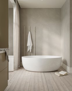 Sandfarget baderom med frittstående badekar, ton-i-ton-vegger og håndkletørkeren Line i en matchende beige nyanse.