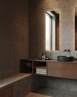 Baderomsinnredning i tre og kalkstein med rund servant, nisjebelysning og innebygd sittebenk.