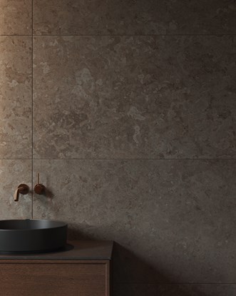 Store natursteinfliser med taktile teksturer, kombinert med moderne servant og armatur – et eksempel på flisetrender i baderomstrender 2026.