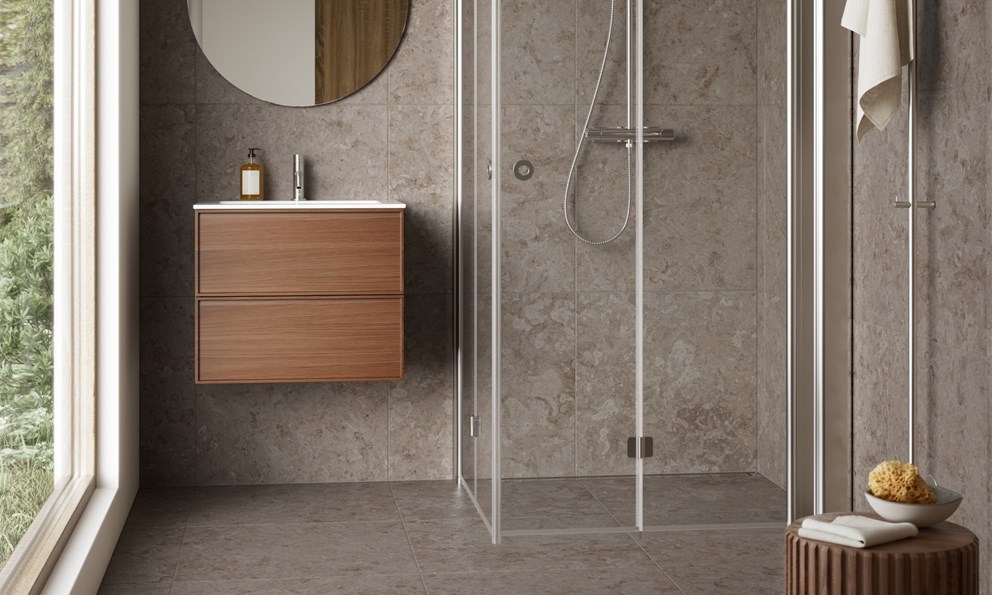 Moderne baderom med naturstein, servantskap i tre og dusj med klart glass.