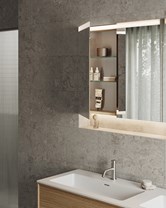 Baderom med naturstein, integrert speilbelysning og åpne hyller – et eksempel på moderne belysningstrender for baderom i 2026.