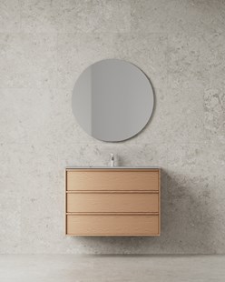 Baderomsinnredning i lyst tre med integrerte grep, rundt speil og kalksteinsvegg.